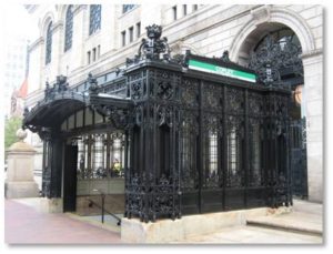 Many Bostonians are familiar with the beautiful Art Nouveau Metro stations of Paris yet they walk right past our city’s own Beaux-Arts masterpiece. The T’s Green Line inbound Copley Station headhouse is one of a kind and unmatched by any other station. Made of ornamental wrought iron, it was designed by the firm of Fox, Jenny and Gale to match and enhance the elegance of the Boston Public Library building behind it. The ironwork echoes the library's graceful Italianate lanterns, and the canopy arch over the stairway to the inbound platform includes a seal with an open book.