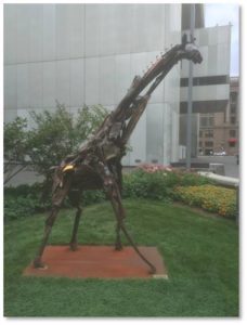 I detoured from my planned route and walked into the small garden in front and to the left of Federal Reserve Plaza’s main entrance. There I got a close look at the 10-foot-tall giraffe sculpted from scrap metal by Madeleine Lord with the assistance of Robert Hesse. It was installed in 2013. 