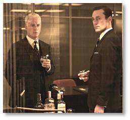 Mad Men's Roger Sterling and Don Draper drinking in the office