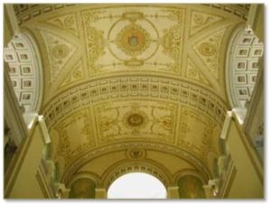 Muralist Albert Haberstroh, of the Boston firm L. Haberstroh and Son, painted the gold and white barrel-vaulted ceiling of the John Adams Courthouse. His design has bands of classical coffers with rosettes that demarcate the sections and frame the Great Seal of the Commonwealth in the center as well as the seals of the four courts that originally occupied the courthouse.