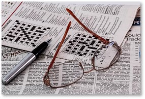 crossword puzzle, newspaper, glasses, pen